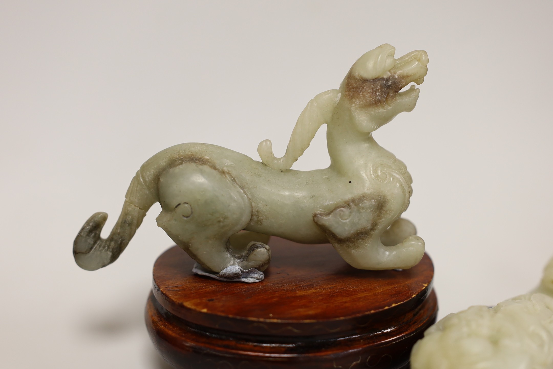 A Chinese pale celadon and grey jade mythical beast on stand and a pale celadon jade belt hook, mythical beast 11cms wide